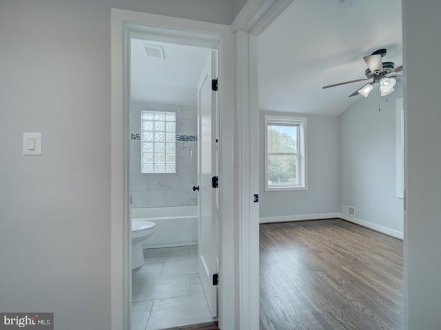 interior space featuring a ceiling fan, visible vents, wood finished floors, baseboards, and toilet