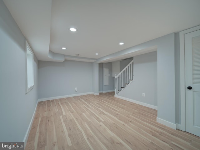 finished basement featuring recessed lighting, baseboards, light wood-style flooring, and stairway