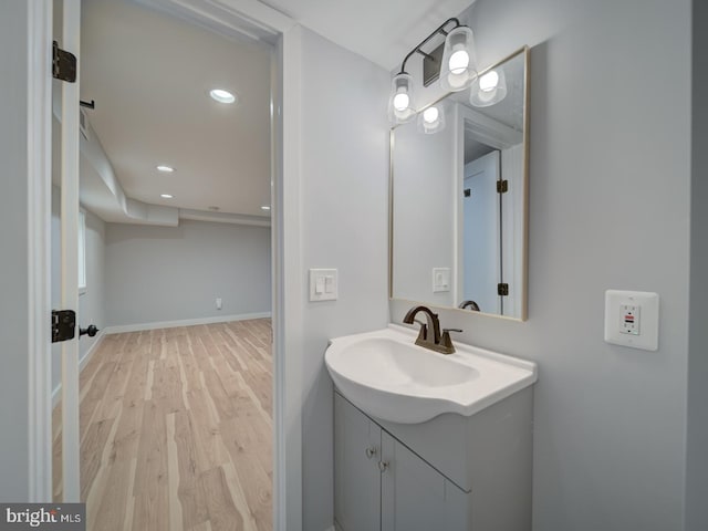 bathroom with vanity, recessed lighting, baseboards, and wood finished floors