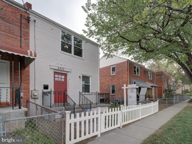 view of front of home with brick siding and a fenced front yard