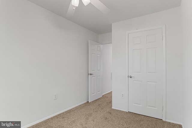 unfurnished bedroom with baseboards, ceiling fan, and light carpet