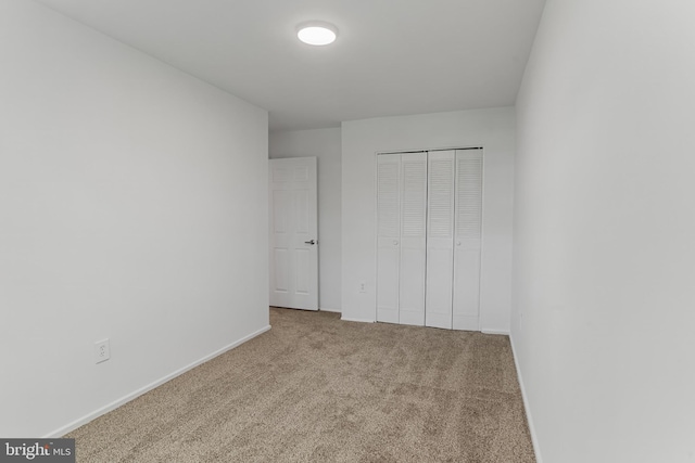 unfurnished bedroom with baseboards, carpet, and a closet