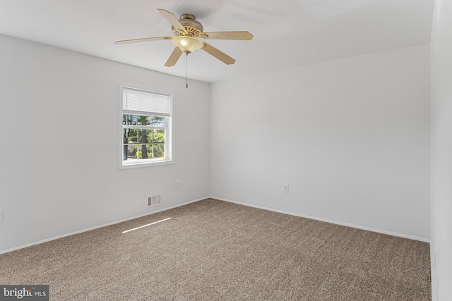 spare room featuring visible vents, carpet flooring, baseboards, and a ceiling fan