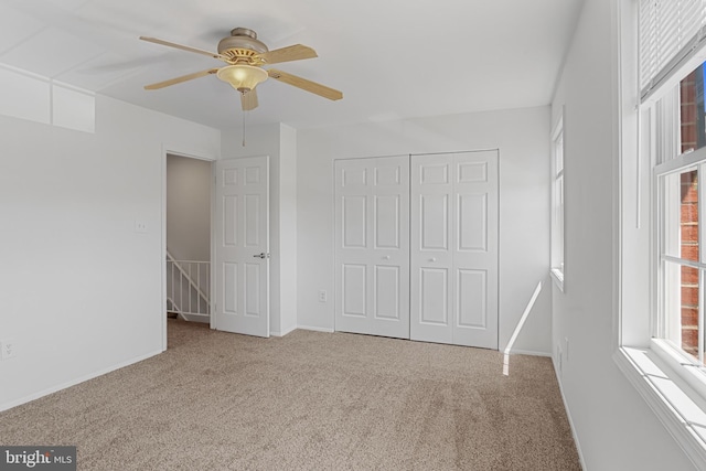 unfurnished bedroom featuring a ceiling fan, baseboards, carpet, and a closet