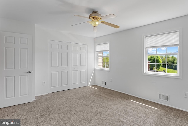 unfurnished bedroom with carpet flooring, baseboards, visible vents, and a closet