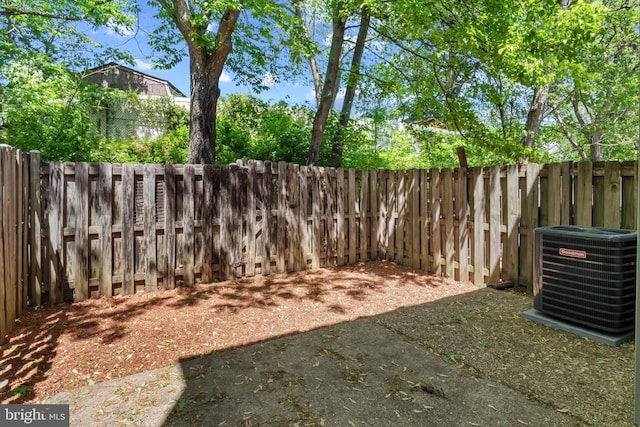 view of yard with a fenced backyard and central AC