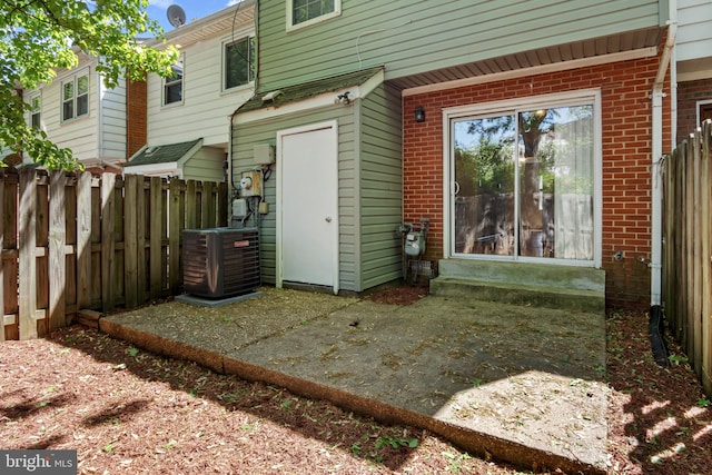 rear view of property featuring central air condition unit, brick siding, fence, and entry steps