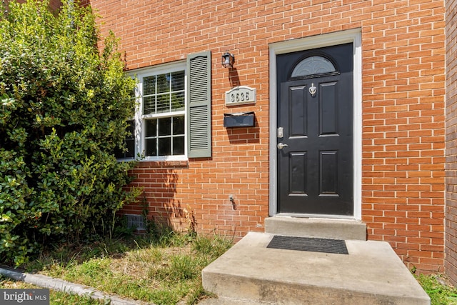 view of exterior entry with brick siding