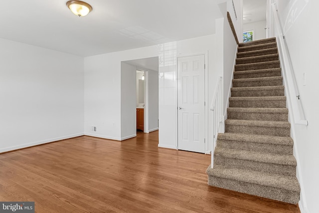 stairway with baseboards and wood finished floors