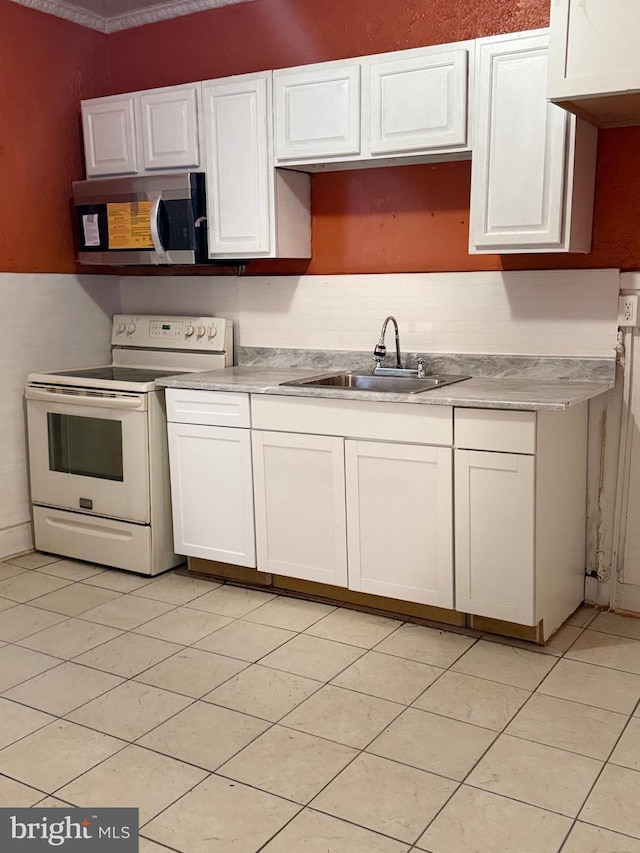 205 E 24th St, Wilmington, DE 19802 - kitchen with stainless steel microwave, white cabinetry, white electric stove, and light countertops