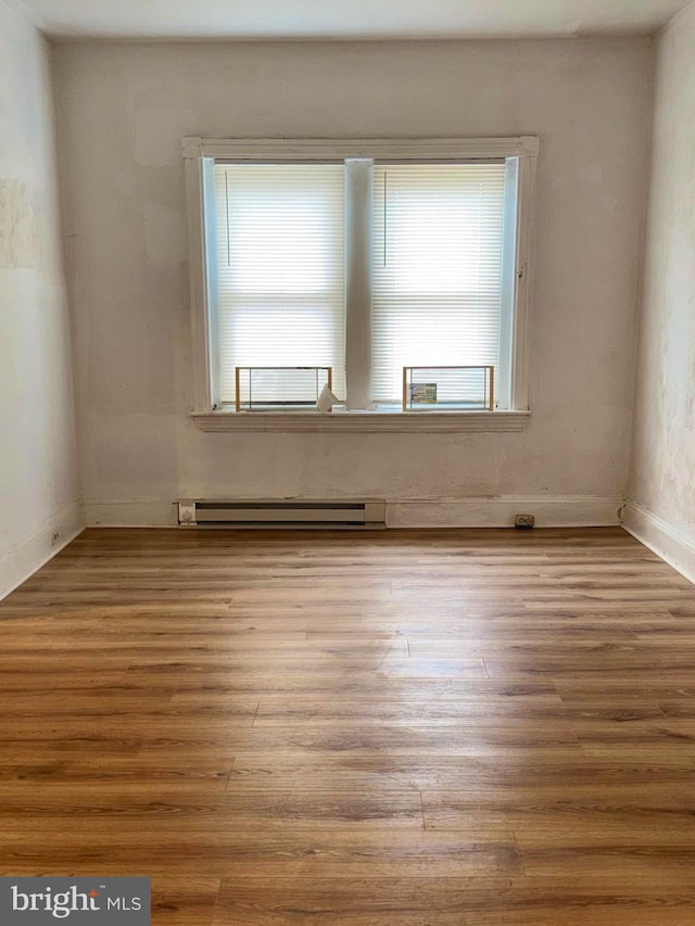 205 E 24th St, Wilmington, DE 19802 - spare room featuring baseboard heating, a wealth of natural light, wood finished floors, and baseboards