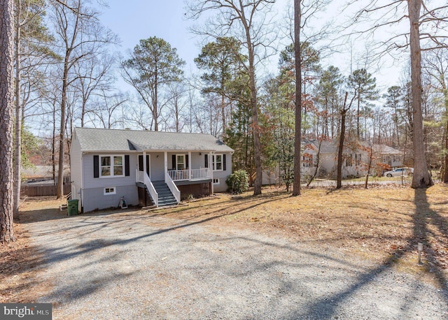 raised ranch with stairs, a shingled roof, and covered porch