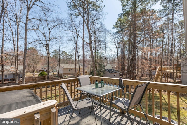 wooden terrace with fence, a residential view, an outdoor structure, and outdoor dining space