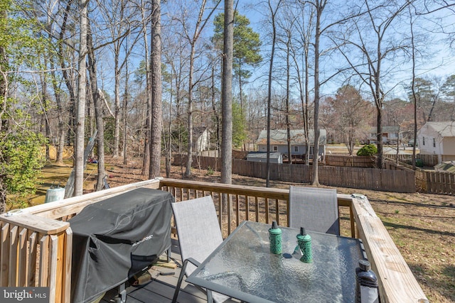 wooden deck featuring a grill, outdoor dining space, and fence