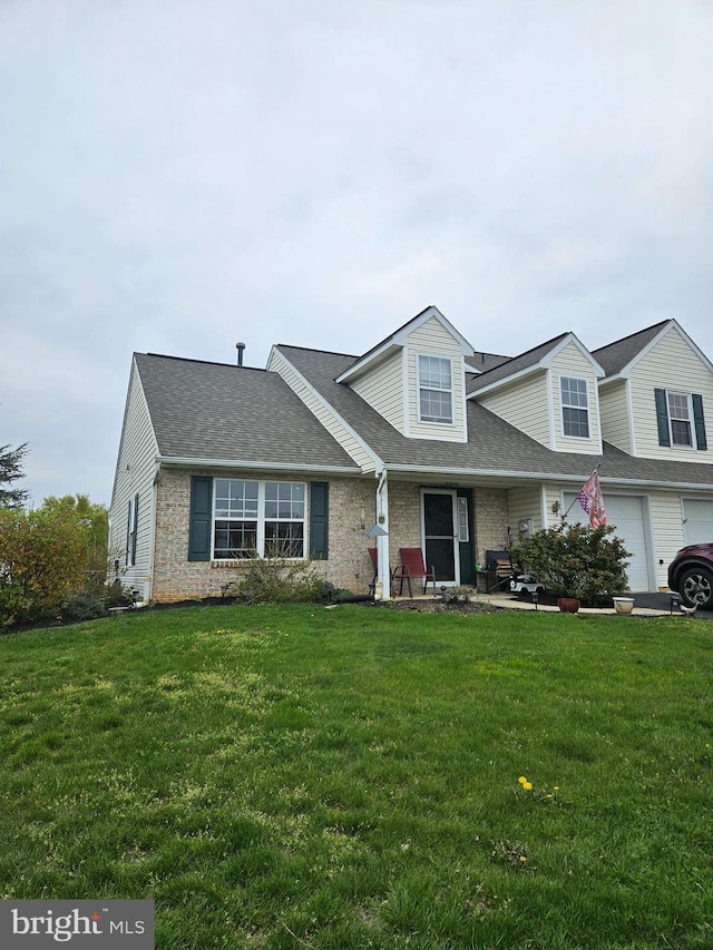 cape cod-style house with brick siding, roof with shingles, and a front yard