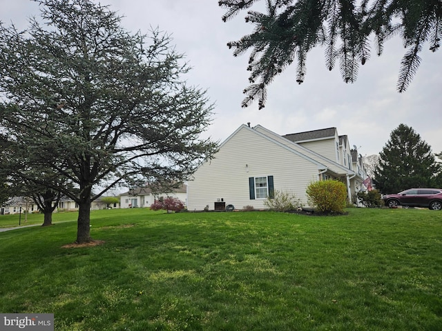 view of side of home with a yard