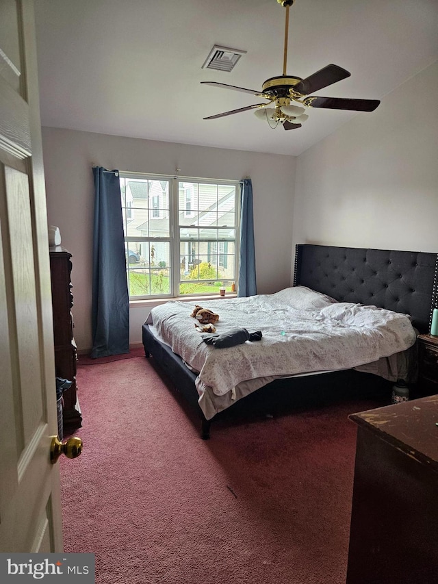 carpeted bedroom featuring ceiling fan and visible vents