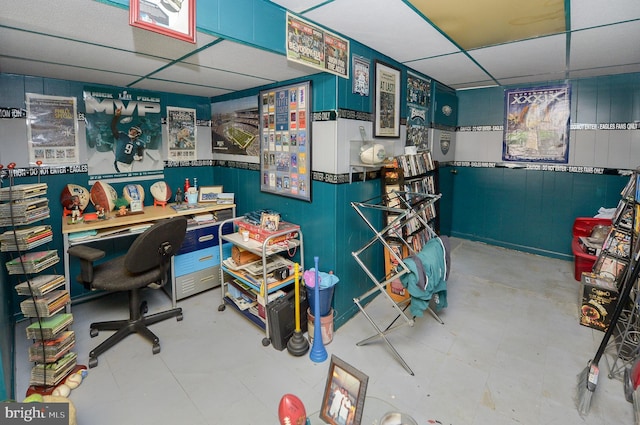 office area with wooden walls, tile patterned floors, and a drop ceiling