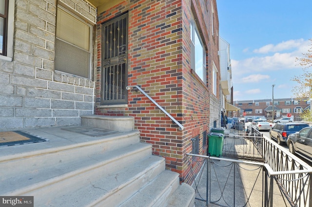 doorway to property featuring brick siding