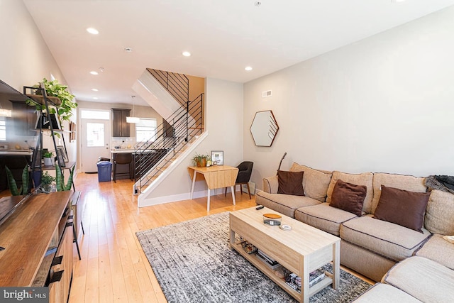 living area featuring visible vents, recessed lighting, stairs, and light wood finished floors