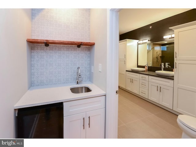 bathroom with toilet, beverage cooler, vanity, and tile patterned flooring