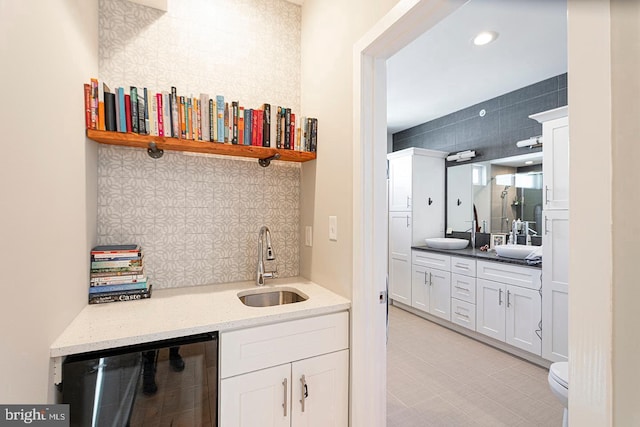 bar featuring wine cooler, a sink, backsplash, and wet bar