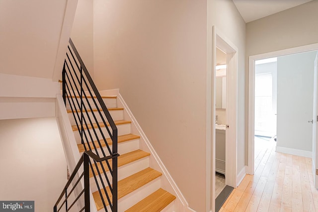 stairs with hardwood / wood-style floors and baseboards