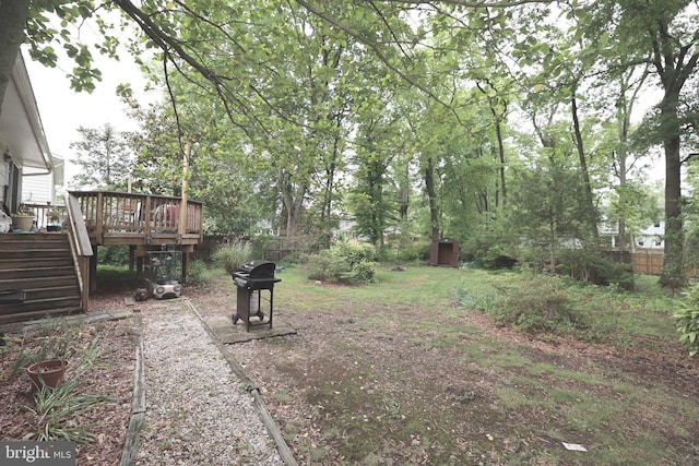 view of yard featuring stairs, a deck, and fence