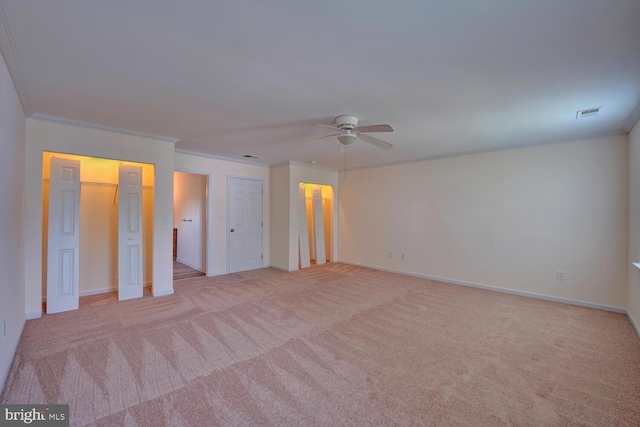 unfurnished bedroom with ceiling fan, baseboards, ornamental molding, and carpet floors