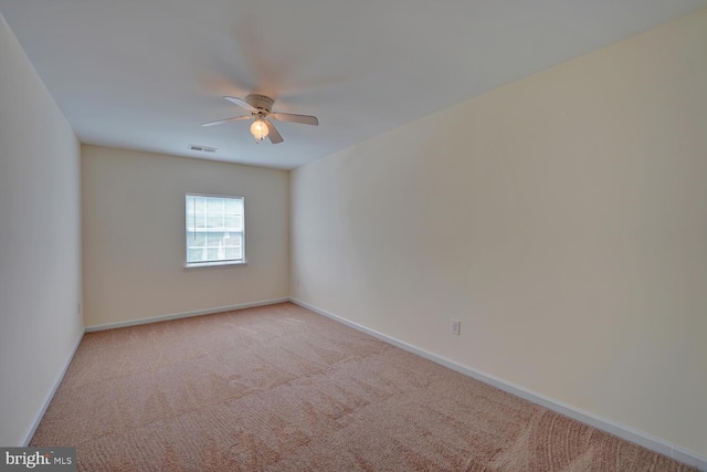 empty room featuring ceiling fan, baseboards, visible vents, and light carpet