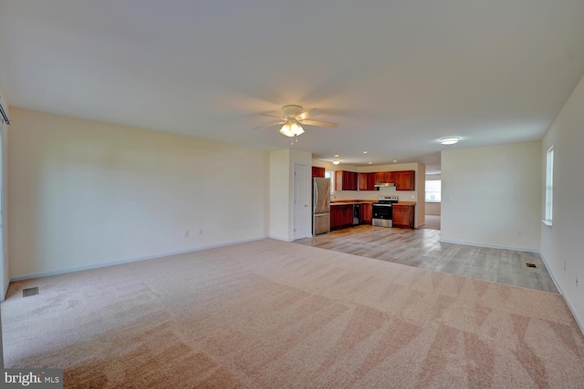 unfurnished living room featuring light colored carpet, a ceiling fan, recessed lighting, and baseboards
