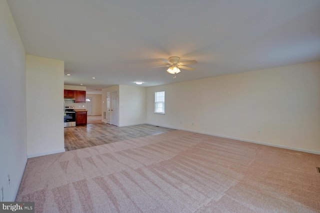 unfurnished living room featuring baseboards, a ceiling fan, light carpet, and recessed lighting