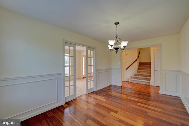 170 Otter Way, Frederica, DE 19946 - unfurnished dining area with hardwood / wood-style floors, wainscoting, a chandelier, stairs, and a decorative wall
