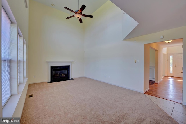 170 Otter Way, Frederica, DE 19946 - unfurnished living room featuring tile patterned flooring, ceiling fan, a fireplace with flush hearth, high vaulted ceiling, and carpet flooring