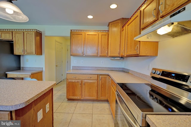 170 Otter Way, Frederica, DE 19946 - kitchen featuring stainless steel range with electric stovetop, under cabinet range hood, light tile patterned floors, freestanding refrigerator, and light countertops