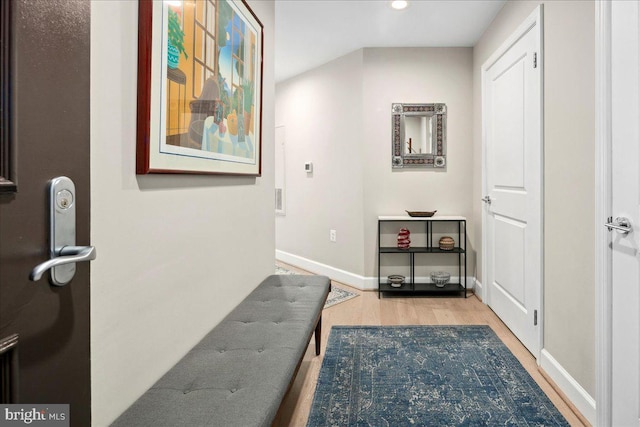 hallway featuring baseboards, wood finished floors, and recessed lighting
