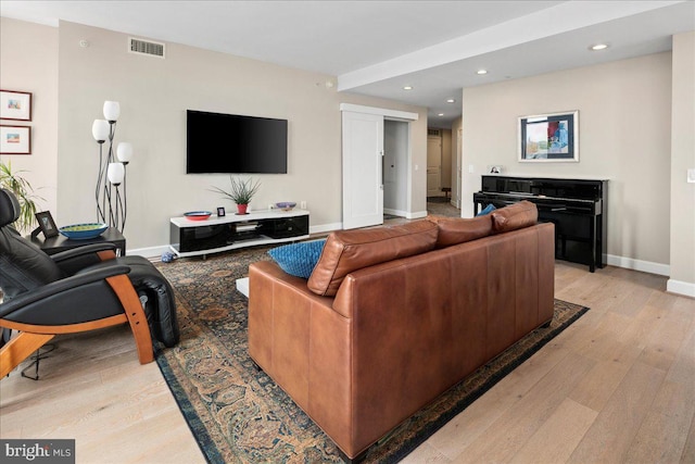 living area featuring visible vents, baseboards, recessed lighting, and light wood-style floors