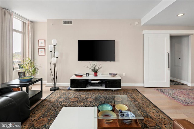 living room with recessed lighting, light wood-style flooring, visible vents, and baseboards