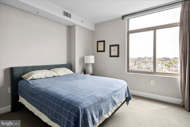 carpeted bedroom featuring baseboards and visible vents