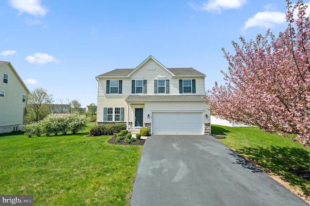 traditional home with an attached garage, a front lawn, driveway, and stone siding