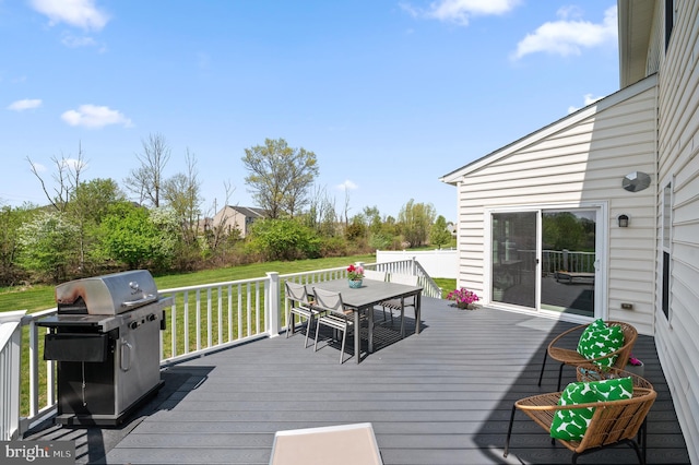 wooden terrace with a lawn, grilling area, and outdoor dining space