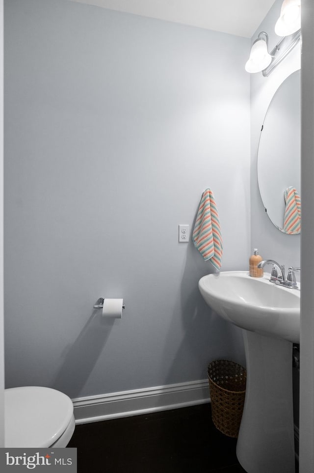 bathroom featuring baseboards and toilet