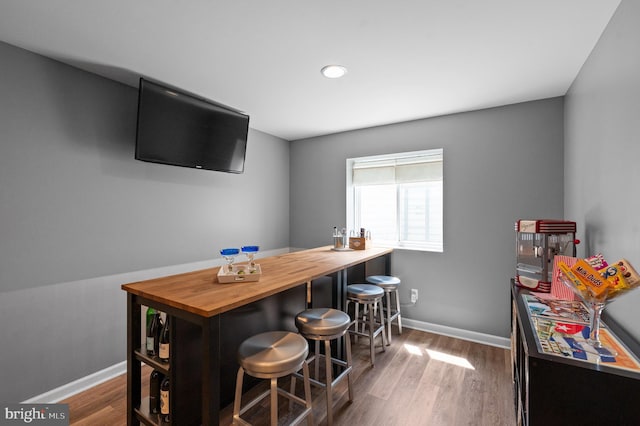 bar with baseboards, recessed lighting, and wood finished floors