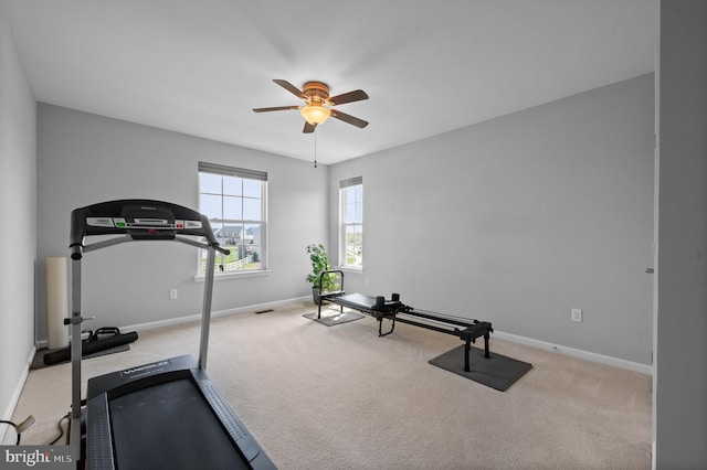 exercise area featuring carpet floors, ceiling fan, and baseboards