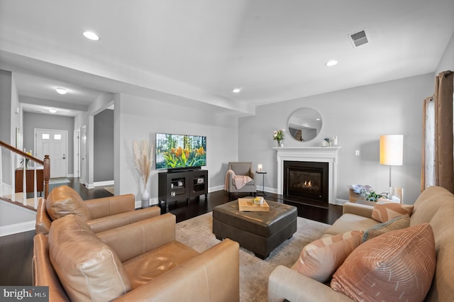 living room with recessed lighting, a glass covered fireplace, wood finished floors, and visible vents
