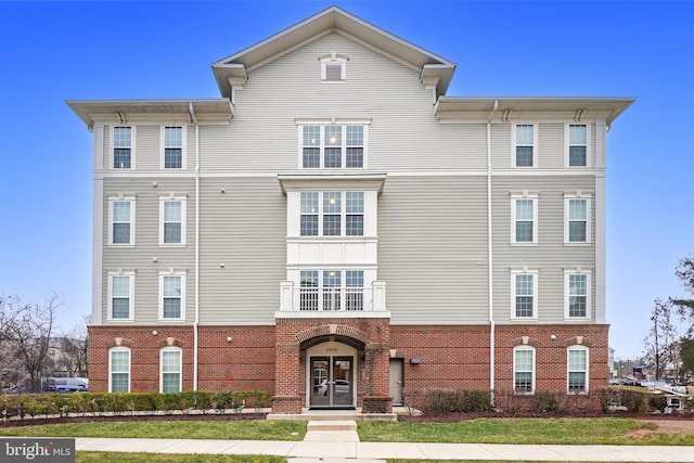 view of front facade featuring brick siding and french doors