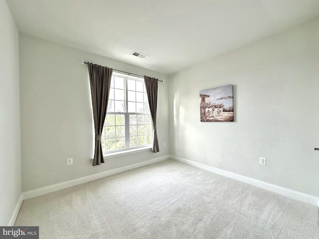 carpeted empty room with visible vents and baseboards