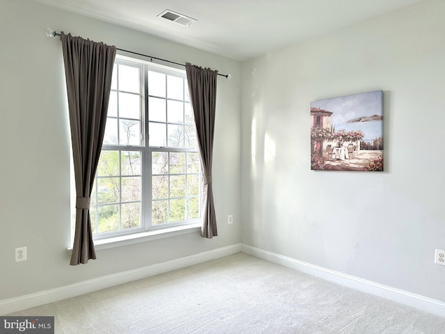 carpeted spare room with baseboards and visible vents