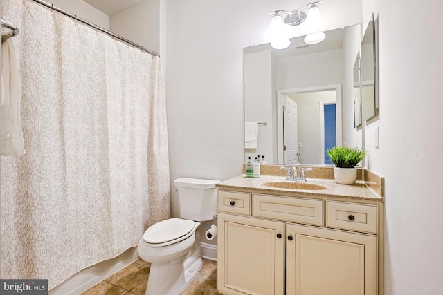 bathroom with curtained shower, vanity, tile patterned flooring, and toilet