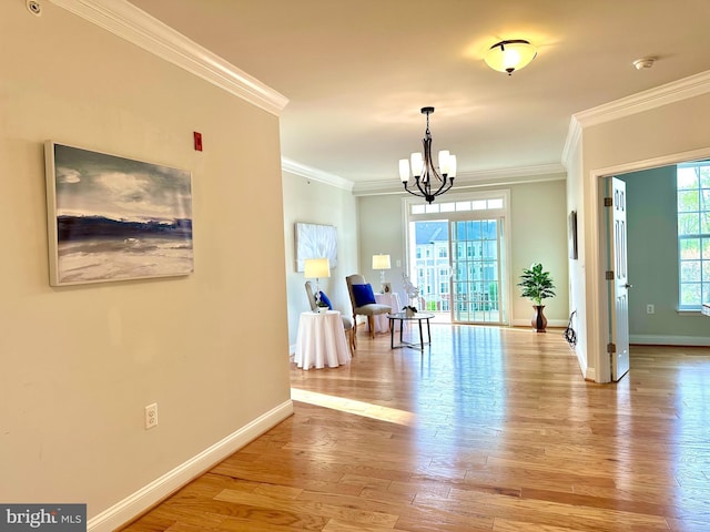 dining space featuring baseboards, a notable chandelier, crown molding, and light wood finished floors